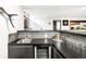 Basement wet bar features a dark countertop, stainless steel sink, wine fridge, and glassware at 6389 S Monaco Ct, Centennial, CO 80111