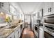 Modern kitchen featuring stainless steel appliances, stone countertops and white cabinetry at 6389 S Monaco Ct, Centennial, CO 80111