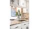 Bright kitchen featuring granite countertops, tiled backsplash, white cabinets, and stainless steel sink at 6389 S Monaco Ct, Centennial, CO 80111