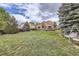 A lush, green backyard with a large, well-maintained lawn, mature trees and deck at 4205 E 106Th Pl, Thornton, CO 80233