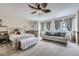 Bright bedroom with a seating area, ceiling fan, and neutral decor at 4205 E 106Th Pl, Thornton, CO 80233