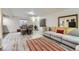 Open-concept living room features modern decor, wood-style flooring, seating, and natural light at 4205 E 106Th Pl, Thornton, CO 80233