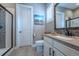 Bathroom featuring a glass shower, toilet, and white vanity with brown countertop, and a decorative mirror at 8463 S Quemoy Ct, Aurora, CO 80016