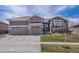 Charming gray home featuring a spacious three-car garage and beautiful stone accents at 8463 S Quemoy Ct, Aurora, CO 80016
