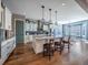 Open kitchen featuring a large island with pendant lights, stainless steel appliances, and hardwood floors at 8463 S Quemoy Ct, Aurora, CO 80016