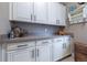 Laundry area featuring abundant storage cabinets, countertops, and modern black hardware at 8463 S Quemoy Ct, Aurora, CO 80016