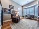 Well-lit office space featuring hardwood floors, a bay window, and a comfortable seating area at 8463 S Quemoy Ct, Aurora, CO 80016