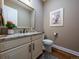 Stylish powder room featuring a granite countertop, decorative mirror, and elegant fixtures at 8463 S Quemoy Ct, Aurora, CO 80016