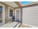 A charming covered porch with a small table and chair, creating a cozy outdoor seating area for relaxing at 853 Mockingbird St, Brighton, CO 80601