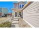 Inviting front porch with a small table and chair, leading to the home's entrance and attractive siding at 853 Mockingbird St, Brighton, CO 80601