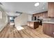 Spacious open-concept kitchen with a center island, modern appliances, and hardwood floors leading to living area at 853 Mockingbird St, Brighton, CO 80601