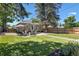 Large backyard featuring a patio, lush green lawn, and a mix of mature trees providing ample shade at 3820 S Grant St, Englewood, CO 80113