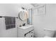 Updated bathroom featuring a modern vanity, stylish round mirror, and fresh white paint at 3820 S Grant St, Englewood, CO 80113