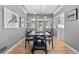 Dining room featuring modern light fixture, wood floors, and an adjacent view of the kitchen at 3820 S Grant St, Englewood, CO 80113