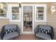 Inviting front porch with seating area offers a view into the home's dining room and updated lighting at 3820 S Grant St, Englewood, CO 80113