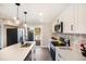The remodeled kitchen features white cabinets, stainless appliances, and a door to the backyard deck at 909 Reynolds Farm Ln # C2, Longmont, CO 80503