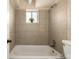 Clean bathroom with a tiled shower/tub and a window for natural light at 1180 Yosemite St # 104, Denver, CO 80220