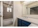 Bathroom with a blue vanity, tiled shower/tub combo, and a window at 1180 Yosemite St # 104, Denver, CO 80220