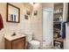 Clean and tidy bathroom featuring a sink, toilet, shower, and storage shelves at 3751 W 85Th Ave, Westminster, CO 80031