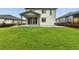 Wide shot of the expansive backyard featuring a lush green lawn and covered patio at 6513 Dry Fork Cir, Frederick, CO 80516