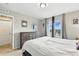 Bright bedroom with neutral walls, a large window, and a wooden dresser offering ample storage at 6513 Dry Fork Cir, Frederick, CO 80516