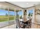 Elegant dining room with a rustic wood table, plush chairs, and a large sliding glass door overlooking the yard at 6513 Dry Fork Cir, Frederick, CO 80516