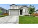 Charming two-story home featuring a well-maintained lawn, gray siding, and an attached two-car garage at 6513 Dry Fork Cir, Frederick, CO 80516