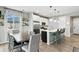 Spacious kitchen and dining area with a modern island, stainless steel appliances, and abundant natural light at 6513 Dry Fork Cir, Frederick, CO 80516