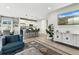 Bright living room with modern furniture, open kitchen, and a stylish entertainment center and hard wood floors at 6513 Dry Fork Cir, Frederick, CO 80516