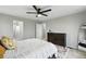 Bright main bedroom featuring large windows, ceiling fan, dresser and access to the bathroom at 6513 Dry Fork Cir, Frederick, CO 80516