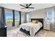Bright main bedroom featuring large windows, ceiling fan and decorative rug at 6513 Dry Fork Cir, Frederick, CO 80516