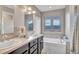 Bathroom featuring double sinks, large bathtub with a window view at 861 Circle Rd, Palmer Lake, CO 80133