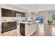 Well-lit kitchen with stainless steel appliances, dark cabinets, granite countertops, and an island at 861 Circle Rd, Palmer Lake, CO 80133