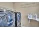 Bright laundry room features gray appliances, shelving, and decorative storage containers at 861 Circle Rd, Palmer Lake, CO 80133