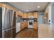 Bright kitchen with stainless steel refrigerator and oven, wood cabinets, dark backsplash, and light countertop at 7110 S Cherry Dr, Centennial, CO 80122