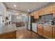 Open-concept kitchen and dining room with wood floors, stainless steel appliances, and modern lighting at 7110 S Cherry Dr, Centennial, CO 80122