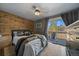 Modern bedroom with wood-paneled accent wall, ceiling fan, and sliding door to balcony at 7110 S Cherry Dr, Centennial, CO 80122