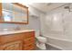 Bathroom featuring wood cabinet and shower-tub combo at 6410 S Dayton St # I05, Englewood, CO 80111