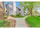 A stone path leads to the building, highlighting the community's landscaping and mature trees at 6410 S Dayton St # I05, Englewood, CO 80111