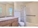 Bright bathroom featuring a shower and tub combo, wood cabinets, and a white toilet at 3752 Red Deer Trl, Broomfield, CO 80020