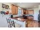 Well-lit kitchen with wood cabinets, breakfast bar, black appliances, and light countertops at 3752 Red Deer Trl, Broomfield, CO 80020
