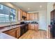Bright kitchen featuring wood cabinets, black appliances, a double sink, and laminate floors at 3752 Red Deer Trl, Broomfield, CO 80020