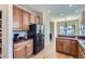 Spacious kitchen with wood cabinets, black appliances, laminate floors, and breakfast bar at 3752 Red Deer Trl, Broomfield, CO 80020