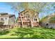 Expansive backyard featuring a two-story deck, lush lawn, and mature trees at 5997 S Yakima St, Aurora, CO 80015