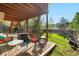 Serene covered patio with brick flooring, outdoor seating, and lush green lawn at 5997 S Yakima St, Aurora, CO 80015