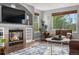 Bright living room featuring a fireplace, built-in shelves, large windows, and plush seating at 5997 S Yakima St, Aurora, CO 80015