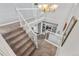 Carpeted staircase with white railing and modern chandelier at 5997 S Yakima St, Aurora, CO 80015