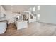 Bright open-concept living space with wood floors, stainless steel appliances, white cabinets, and a modern staircase at 39460 Congress Ln, Elizabeth, CO 80107