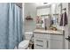 Cozy bathroom with vanity, granite countertop, and a shower with a blue patterned curtain at 4021 S Teller St, Lakewood, CO 80235