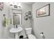 Well-lit powder room with pedestal sink, modern fixtures, and decorative wall art at 4021 S Teller St, Lakewood, CO 80235
